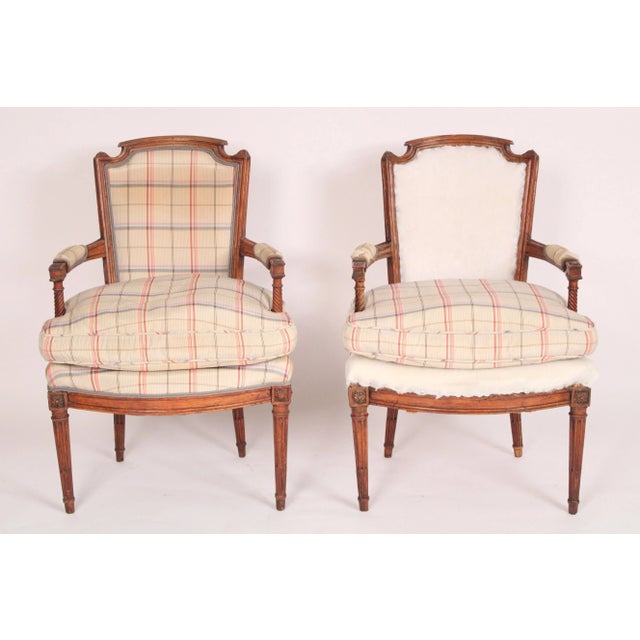 Pair of Louis XVI beech wood armchair frames, circa 1800. Seat cushions are 50% down and 50% feathers.