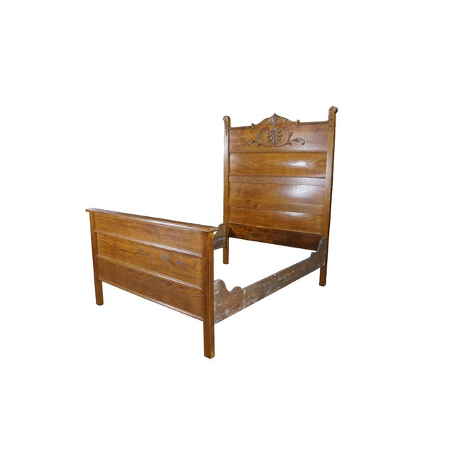 A stately antique golden oak high-back late 19th-century American bed. Showcasing a warm honey finish that highlights the...