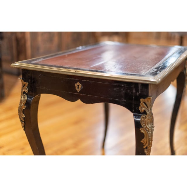 Ebonized wood writing desk with leather top, single drawer and brass appliques. Circa: 1870