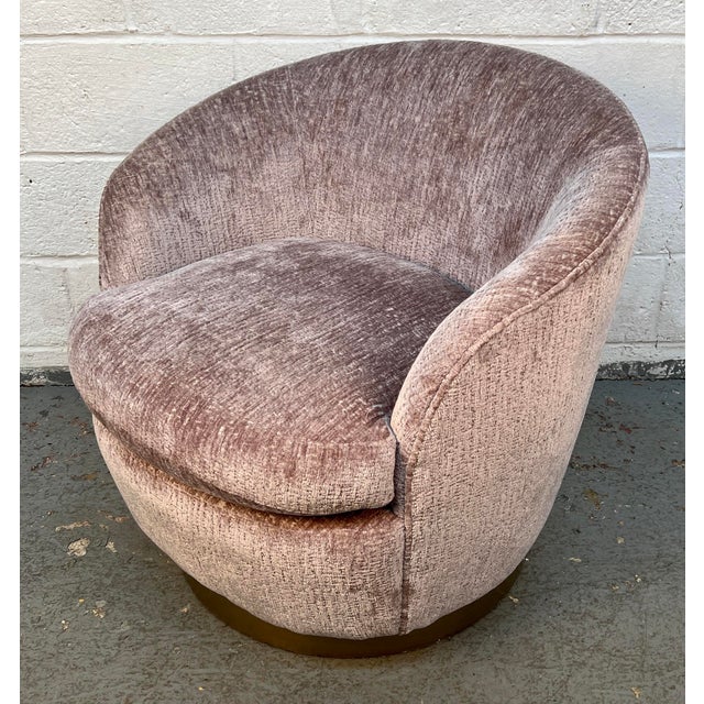 Add timeless style and comfort to your space with this elegant vintage barrel swivel chair. Upholstered in a soft blush-...
