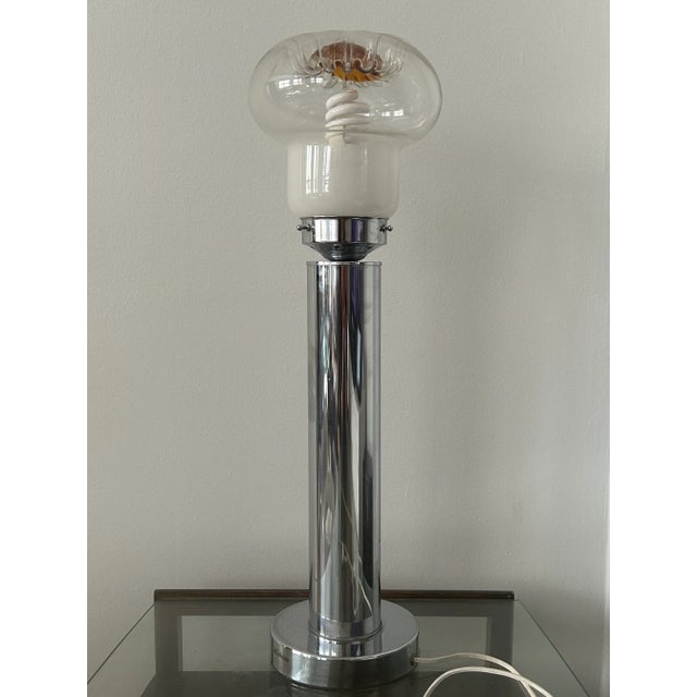 This table lamp is mid-century modern from the 1970's, has a chrome base with a Murano glass shade in milky white,...