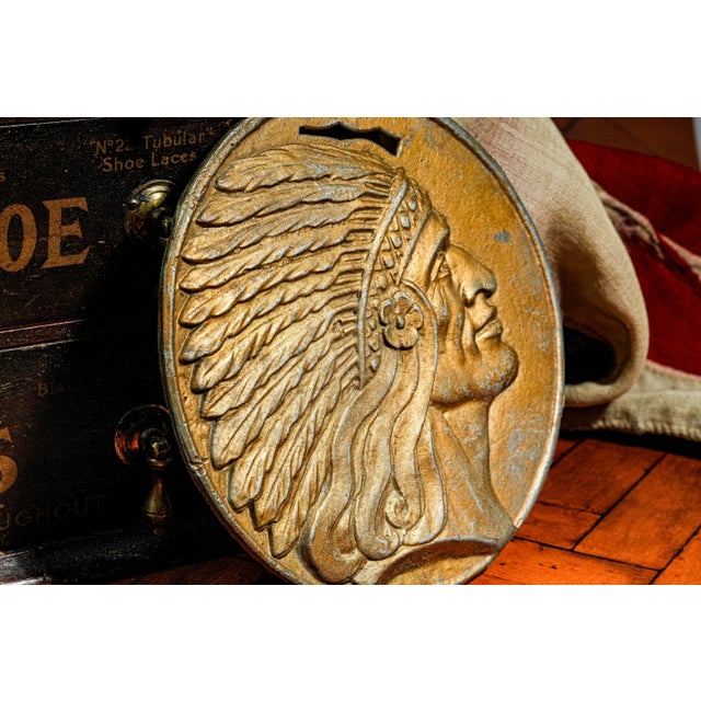 A striking example of early Americana decorative art, this solid cast metal medallion plaque depicts a Native American...