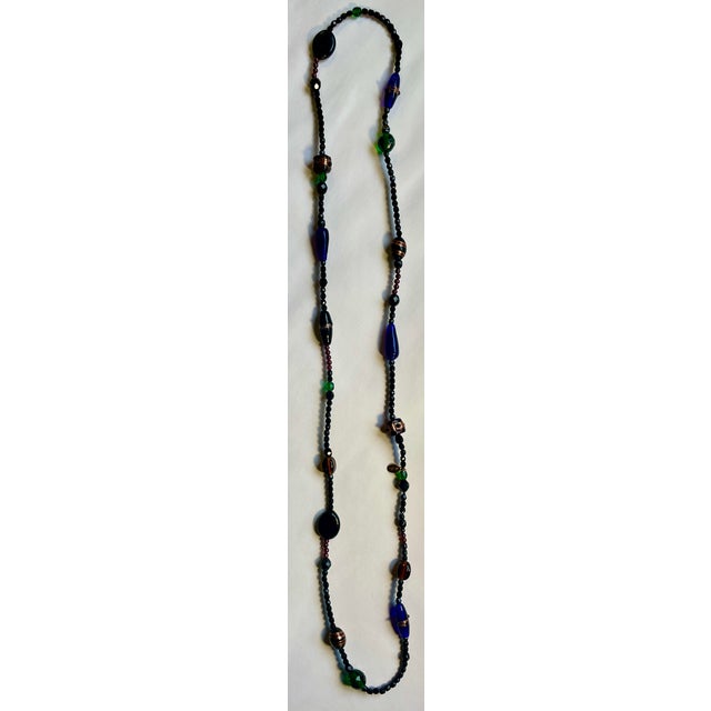 Beautiful Czech molded and patterned glass beads. Mostly black with cobalt blue, emerald green, amber, and a copper-...