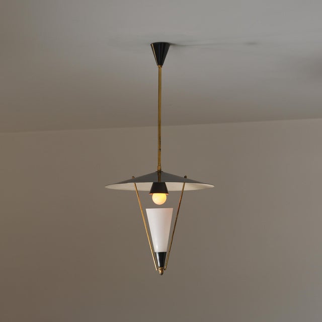 Italian pendant light dating from the 1950s, characterized by a refined mid-century composition in brass, black lacquered...