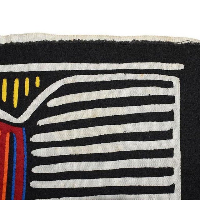 A large brightly colored fabric appliqué collage tapestry of a bird with fish in its mouth. This dramatic fabric piece...