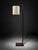 A modern minimalist floor lamp with a clean rectangular frame, square base, and cream fabric drum shade. The frame...