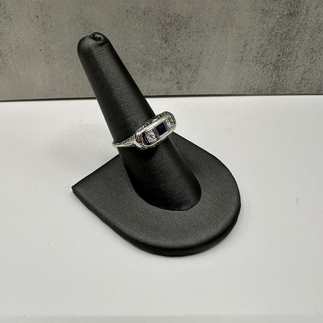 This vintage 3-Stone Princess Ring in 18kt white gold features a brilliant cut round diamond (approx. 3.3mm, GH SI...