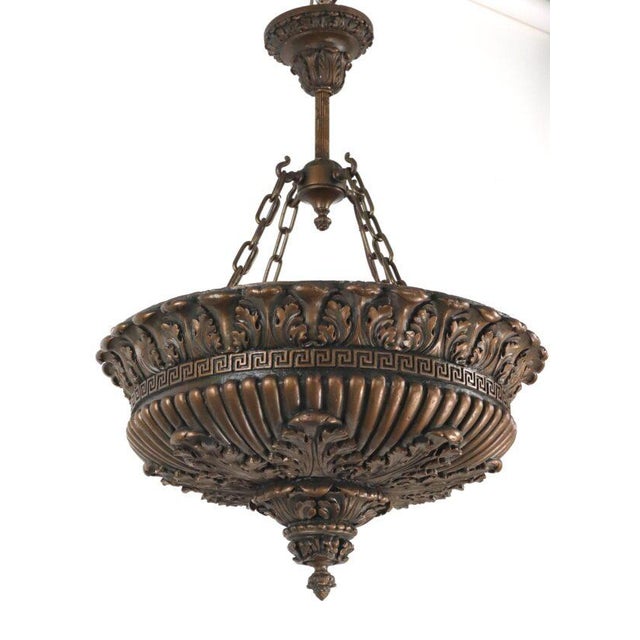 Neoclassical style pendant light made of bronze painted Edwardian style cast composition plaster, and a bronze finish...