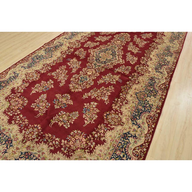 An authentic vintage traditional Kerman rug hand-knotted with fine wool and natural dyes. This rug features a central...