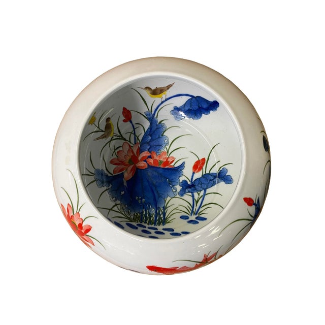 This is a decorative porcelain round bowl with a white base finish. The theme is floral lotus fishes birds pattern...