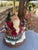Whimsical Christmas table lamp features a hand-painted resin base depicting Santa Claus carrying a birdhouse and basket of...