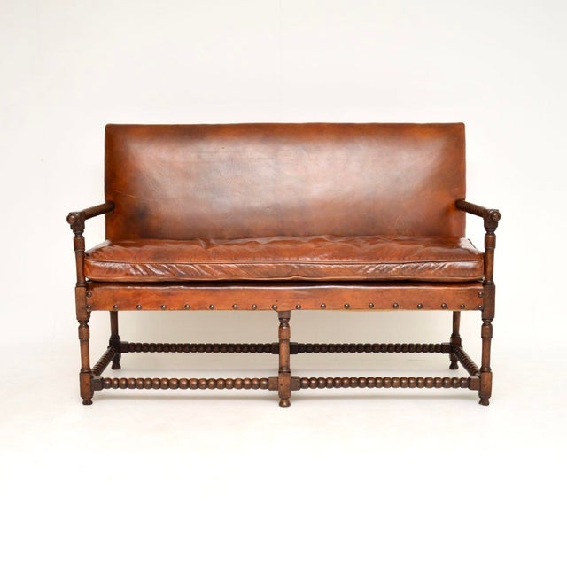 A wonderful antique leather and carved oak bobbin sofa. This was made in England, it dates from around the 1890-1910...
