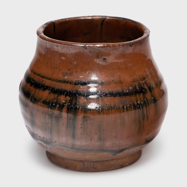 This antique Chinese jar from the early 20th century is cloaked inside and out with a beautiful drip glaze of red-brown...