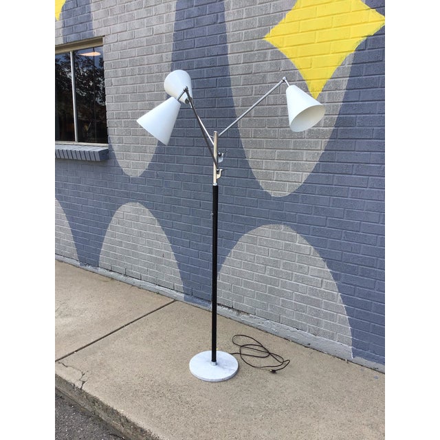 Striking vintage mid-century modern three-arm floor lamp featuring a sculptural atomic-era silhouette with adjustable cone...