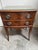 Elegant vintage two-drawer nightstand featuring beautifully figured wood grain, a warm reddish-brown finish, and classic...
