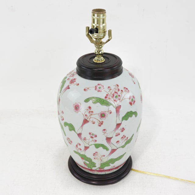 A beautifully crafted vintage Chinese porcelain ginger jar lamp adorned with a delicate hand-painted floral and vine...