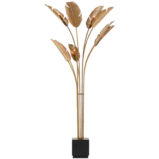 The Tropical Grande Floor Lamp is made of brass in a vintage brass finish with life-like leaves rising from the black...