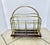Antique English Victorian era newspaper and magazine rack featuring a brass frame on a dark wood base.