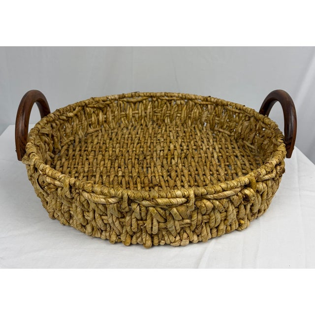 A woven seagrass tray with wood handles, offering natural texture and relaxed coastal style. Ideal for serving or styling...