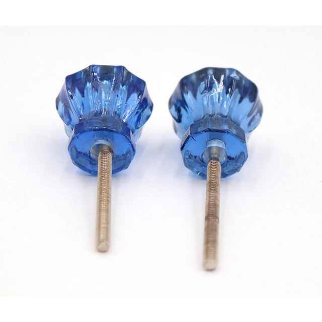 Vintage cabinet or drawer knobs made of blue glass with a fluted design. The original mounting nuts are not included. Good...