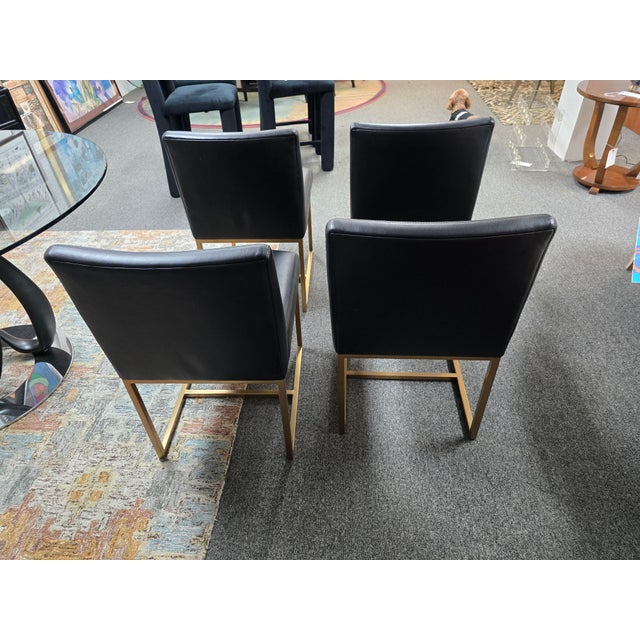Set of 4 dining chairs in leather and brass tone frames by Restoration Hardware.