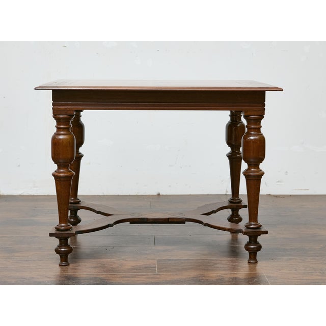 A 19th-century Italian walnut side table showcasing refined craftsmanship and decorative detail. The rectangular top is...