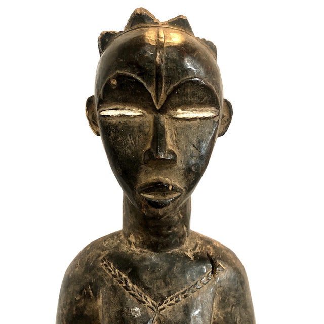 This sculpture is a standing female figure from West Africa. As standalone wooden figures are relatively rare compared to...