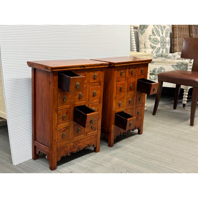 Design Plus Gallery presents a Pair of Vintage Chinese Wood Apothecary Nightstands. Each cabinet is constructed of wood...
