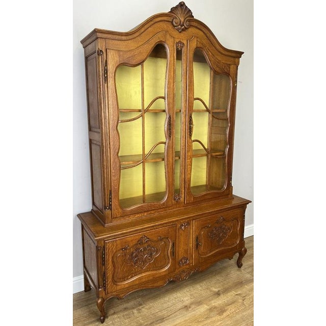This elegant Vintage French Louis Oak Bookcase is a beautifully crafted display cabinet featuring graceful curved glazing,...