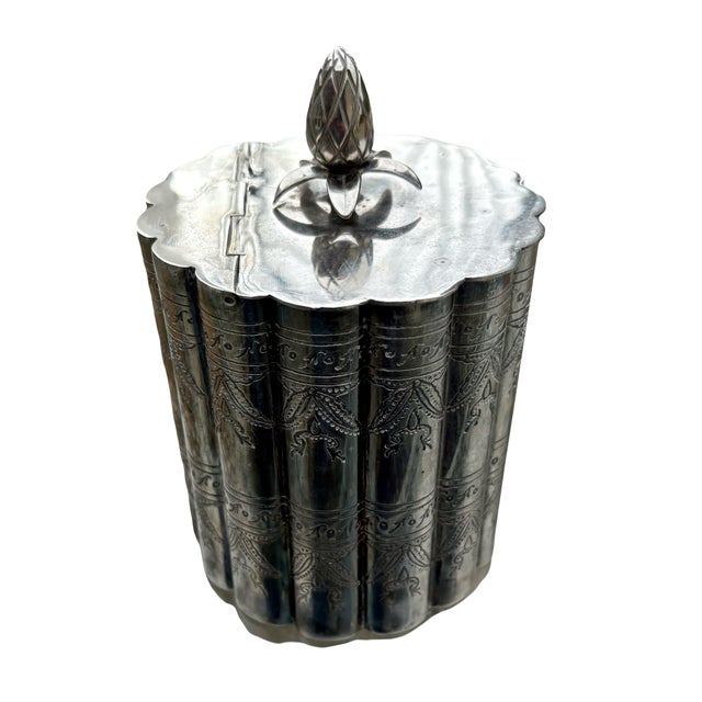 This object is a vintage silver-plated tea caddy, often used as a decorative jewelry or trinket box. It features a...