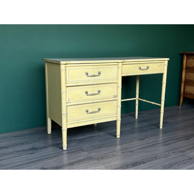 1970’s Faux Bamboo Canary yellow desk of four drawers with metal hardware and Formica top. This desk is part of the Bali...
