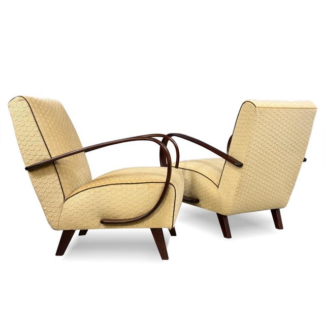 A refined pair of armchairs produced by Interiér Praha, representing classic Czechoslovak design of the 1950s. The...