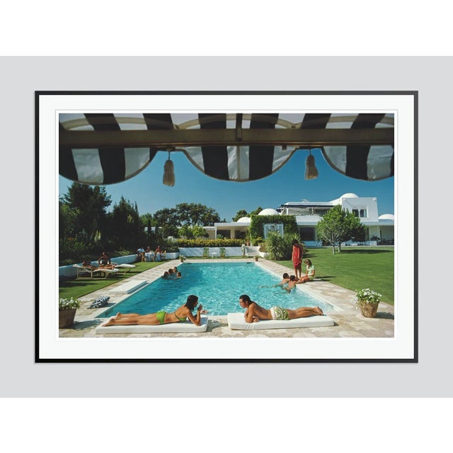 Poolside In Sotogrande' by Slim Aarons Open Edition Bathers round a pool in Sotogrande, Spain, August 1975. (Photo by Slim...