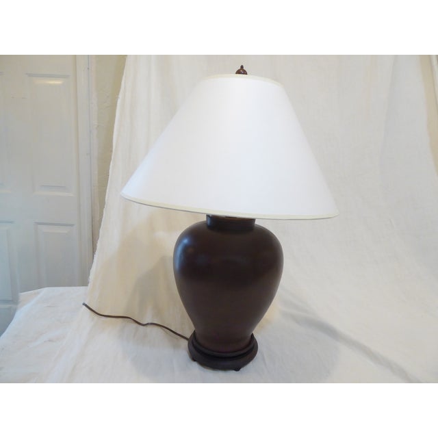 This 19th Century bronze vase, made into a lamp with a hardwood base, is shown with an 18"Diameter white paper shade. The...