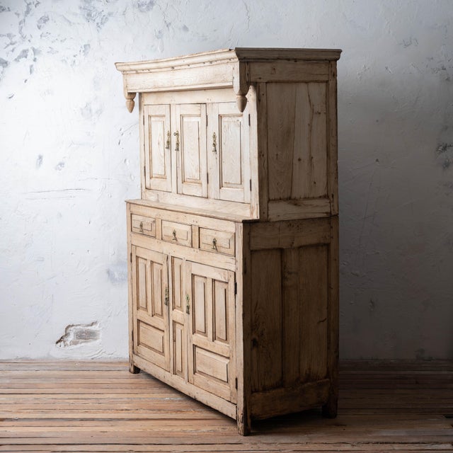 Welsh bleached oak cwpwrdd deuddarn, circa 1700. Classic two-part form with drop pendant cornice turnings above three...