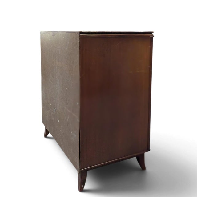 A vintage two-door storage cabinet with dramatic, mirror-matched flame-pattern mahogany veneers. Framed door panels, a...