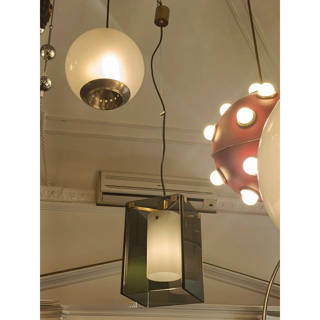 This elegant Model 2211 pendant lamp, designed by Max Ingrand for Fontana Arte in the 1960s, features gray smoked glass...
