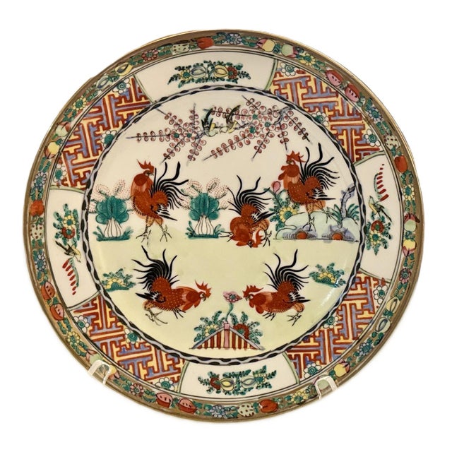 A striking pair of vintage Chinese porcelain plates, each featuring a beautifully detailed rooster scene surrounded by...
