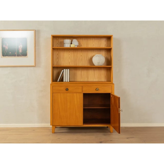 Wonderful two-piece chest of drawers from the 1950s. High-quality body in ash veneer with two drawers, two cabinet doors,...