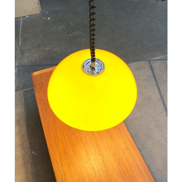 Rare train pendant lamp by Guzzini designed by Luigi Massoni. The large plastic shade is finished in yellow. On the...