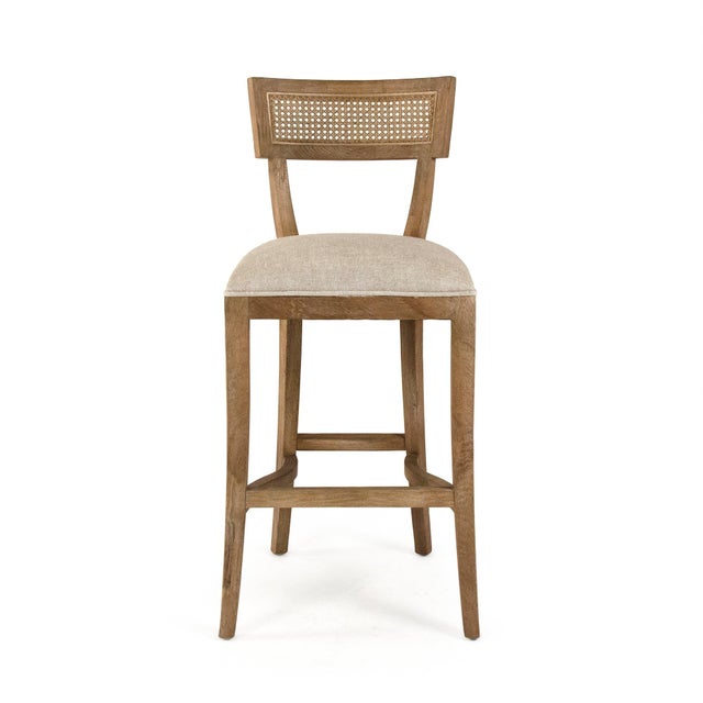 The Carvell Cane Back Bar Stool from Zentique pairs the klismos-inspired silhouette with a woven cane back panel at bar...