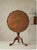 An elegant Chippendale Revival mahogany occasional table featuring a generously sized round top with a scalloped, raised...