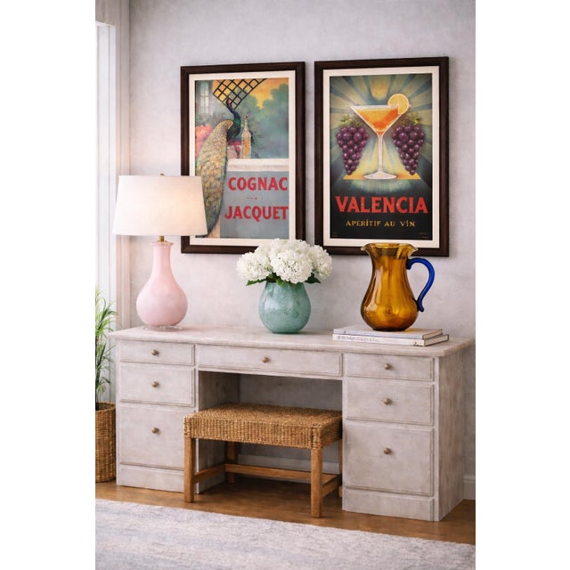 A richly toned amber art glass pitcher with a sculptural silhouette and striking cobalt blue handle, this hand-blown style...