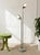 A sleek vintage floor lamp featuring two independently positioned dome shades set at different heights along a tall,...