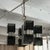 This striking Mid-Century Modern chandelier features a bold architectural silhouette defined by a central chrome pillar...