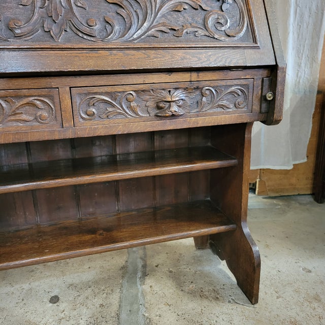 This Late 19th Century Carved Front Victorian Oak Drop Front 2 Drawer Bureau has some very unique carved Griffin head...