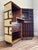 Exclusive bar cabinet in burgundy that is easy to move. Made in the style of turn-of-the-century travel trunks. Solid...