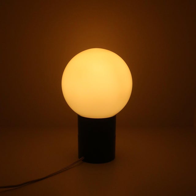 "A very cool mid-century modern lamp with a black base and removable frosted glass globe to cover the lightbulb inside....