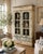 Charming French Provincial display cabinet featuring a beautifully timeworn painted finish in soft cream and sage green...