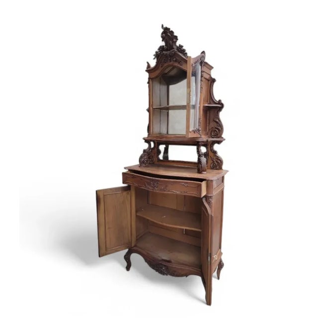 Antique French Carved Ornate Bombe Vitrine Cabinet Featuring intricate carved decorations and brass lock hardware, this...